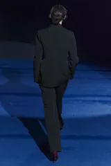 Pantalón negro de tiro medio, con trabillas en la cintura, bolsillos laterales y de vivo en la espalda, raya planchada en el delantero y pierna recta.