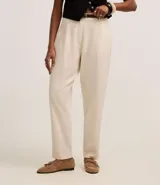 Pantalón zanahoria de cintura alta color borgoña, con trabillas, pliegues y cinturón fino de cuero sintético.