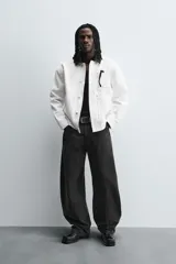 Pantalón de jean celeste con efecto lavado, corte holgado desde la cadera que se estrecha ligeramente en el bajo, tiro medio, cinco bolsillos y cierre frontal con cremallera y botón.