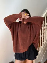 Buzo color marrón con cuello alto y mangas largas terminadas en volados.