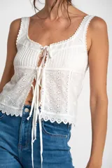Musculosa blanca de algodón con bordado calado, alforzas y terminaciones de puntilla.