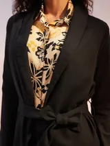 Blazer color crema de manga larga, con solapas amplias y cinturón para ajustar a la cintura.