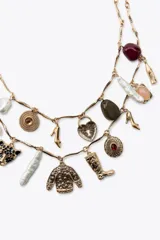 Set de dos collares dorados con cadena de eslabones y dijes colgantes con forma de labial, piedras de colores, zapatos de tacón, sweater, bota, candado de corazón, cabeza de pantera y perlas.