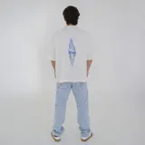 Remera color beige de corte holgado con estampado pequeño en el pecho.
