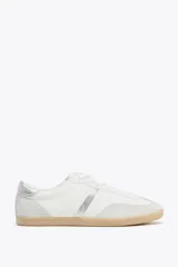 Zapatillas deportivas blancas con detalles en cuero sintético color crema y plateado.