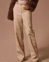 Pantalón de vestir color beige claro, de corte recto y tiro alto, con textura de piel de serpiente grabada.