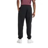 Pantalón de jogging negro de felpa perchada con ajuste holgado, cintura y bajos elásticos, cordón regulable, bolsillos laterales y trasero, y logo estampado en el muslo izquierdo.