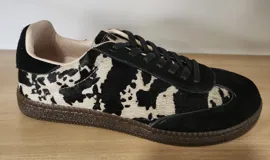 Zapatillas urbanas con estampado animal print en blanco y negro, detalles en gamuza negra y cordones negros. Incluye cordones crudos extra.