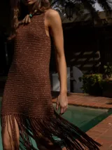 Vestido corto tejido a crochet color marrón con flecos en el ruedo y cuello redondo.