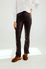 Pantalón de cuero sintético color cobre, de corte ajustado y con aberturas en el ruedo.