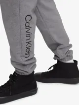 Pantalón de jogging gris de algodón, con cintura elástica, bolsillos laterales y traseros, y logo de Calvin Klein bordado en la pierna izquierda.
