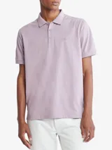Chomba manga corta color lila con cuello clásico y tapeta de dos botones. Tiene el logo de Calvin Klein bordado en el pecho. Corte regular.