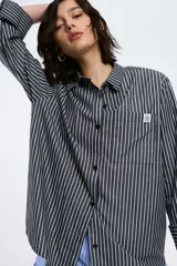 Camisa a rayas verticales rojas y blancas, de corte recto, con cuello clásico, manga larga y bolsillo en el pecho.