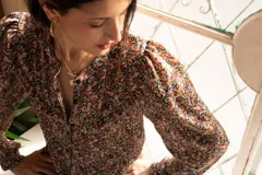 Camisa de gasa estampada con flores, corte clásico, cuello redondo, mangas largas abuchonadas y cierre frontal con botones.