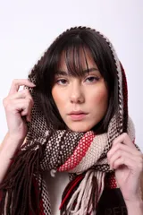 Bufanda larga tejida en telar con lana merino, con diseño a rayas verticales en tonos marrón, beige y rojo.