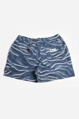 Short de baño blanco con estampado de hojas en tonos naranja, verde y rosa. Cuenta con cintura elástica, cordón ajustable, bolsillos laterales, suspensor interno y logo estampado.