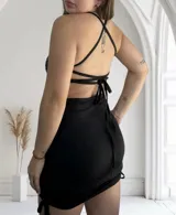 Minivestido negro ajustado al cuerpo, con escote recto y breteles finos. Decorado con strass plateados.