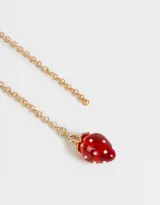Cadena dorada con dije de frutilla transparente con incrustaciones plateadas.