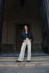 Pantalón de corte recto con estampado de piel de cocodrilo en tonos beige y negro.