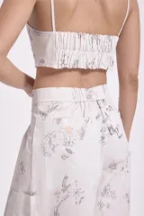 Top crop blanco con estampado de dibujos en tonos grises y marrones, con escote en V y breteles anchos.