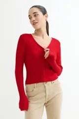 Sweater rojo de tejido de punto acanalado, con escote en V y cierre frontal con cremallera.