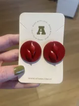 Par de aros circulares color rojo con aplique en forma de hoja.