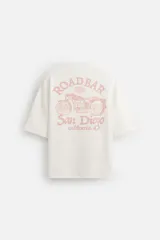 Sudadera blanca de algodón con efecto lavado, corte boxy y manga corta. Presenta cuello redondo y estampado frontal y trasero en color naranja con la leyenda "Fast Race Motorcycles Division".