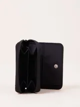 Billetera fucsia con cierre de cremallera y parche de goma negro con logo.