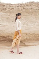 Túnica midi color beige con corte geométrico en lila y verde. Tiene cuello mao con botones y mangas 3/4.