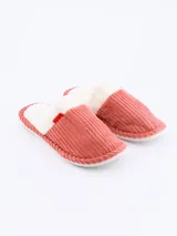 Pantuflas cerradas color rosado, con interior de felpa blanca y detalle de moño rojo.