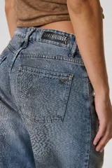 Pantalón de jean azul con estampado de zorros en tonos marrones.