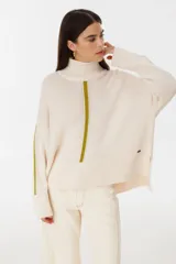 Sweater de punto color crudo con detalles en color tostado y cuello alto.