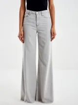 Pantalón de denim gris claro, de corte acampanado, con cierre y botón. Tiene dos bolsillos delanteros y dos traseros.