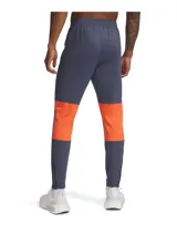 Pantalón deportivo Under Armour Challenger de hombre, color gris con detalles en naranja y logo de la marca en blanco.