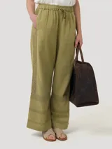 Pantalón de lino y viscosa color beige, de corte recto, con tiro alto, bolsillos laterales y ajuste en la cintura con hebillas.