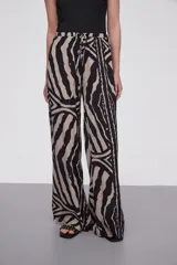Pantalón de viscosa con estampado abstracto en tonos beige y negro, de corte palazzo y cintura con lazo ajustable.