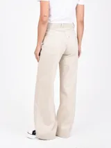 Jean de tiro alto, color beige claro con efecto desgastado, corte ancho y pierna acampanada.