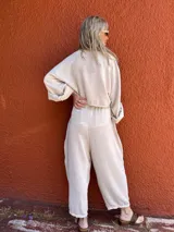 Pantalón de corte amplio color beige, con cintura elástica y lazo ajustable.