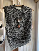 Chaleco tejido color crema, con cuello alto y sin mangas.