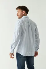 Camisa celeste a rayas rojas de hombre, manga larga, con bolsillo y logo bordado.