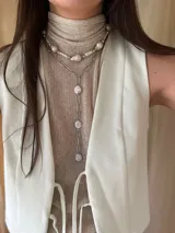 Collar corto de perlas de río alargadas y ovaladas, con cuentas de acero quirúrgico y bolitas con baño de oro. Cierre con cadena de acero quirúrgico y gancho para regular el largo.
