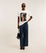 Remera de algodón color blanco, con cuello redondo y mangas cortas. Estampa frontal con la pintura "La joven de la perla" de Johannes Vermeer.