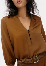 Blusa color marrón con escote en V y botones.