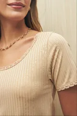 Remera color ladrillo de manga corta y cuello redondo con puntillas en mangas y escote.