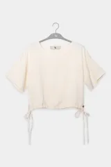 Top color crema de manga corta con cuello redondo y lazos ajustables en los laterales.