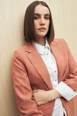 Blazer color beige de corte clásico en tela jaspeada, suave al tacto, liviana y con caída relajada.