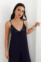 Mono de mujer color azul marino, con escote en V profundo y tirantes finos. Presenta un detalle de tela satinada en el escote.