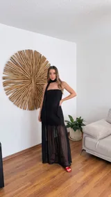 Vestido largo negro de tejido de punto con escote recto y breteles finos. La falda es de encaje transparente. Incluye una bufanda fina al tono.