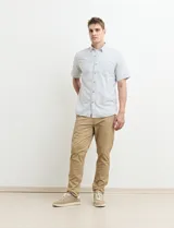 Camisa de manga corta a rayas verticales celestes y blancas, con cuello abotonado y corte clásico.