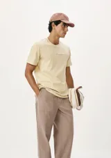 Camiseta blanca de algodón con cuello redondo y mangas cortas. Estampa rectangular con borde negro que contiene la frase "NATURAL ATMOSPHERE" en letras mayúsculas y una imagen de montañas y mar.